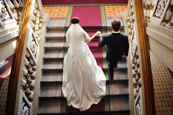 bride and groom walk up the stairs