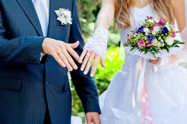 Groom embraces the bride, the bride holds a wedding bouquet — Stock Photo, Image