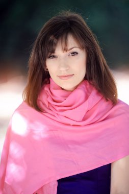 Parkta bir bankta oturmuş bir mavi elbiseli güzel kadın