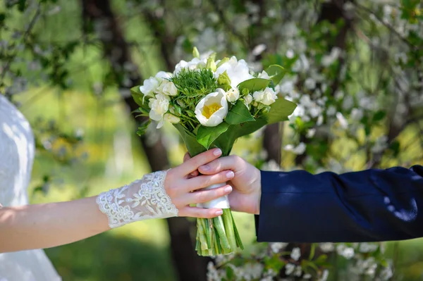 Bruden går med brudgummen i händerna på ett vackert bröllop bou — Stockfoto