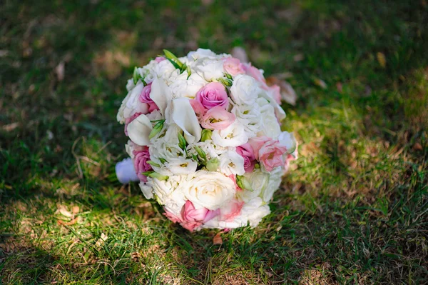 Belo buquê de noiva deitado na grama — Fotografia de Stock