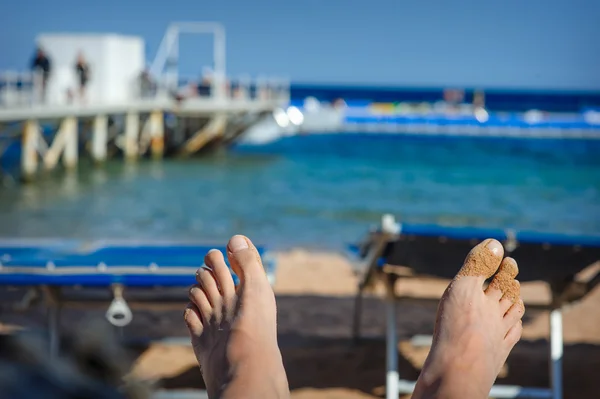 Kadının ayak kum deniz arka plan üzerinde — Stok fotoğraf
