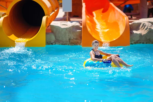 Schönes Mädchen reitet auf einer Wasserrutsche — Stockfoto