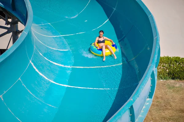 Schönes Mädchen reitet auf einer Wasserrutsche — Stockfoto