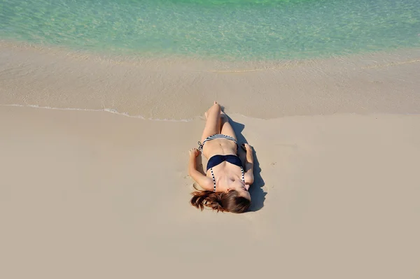 Güzel kız bir kumsalda yalnız sunbathes — Stok fotoğraf