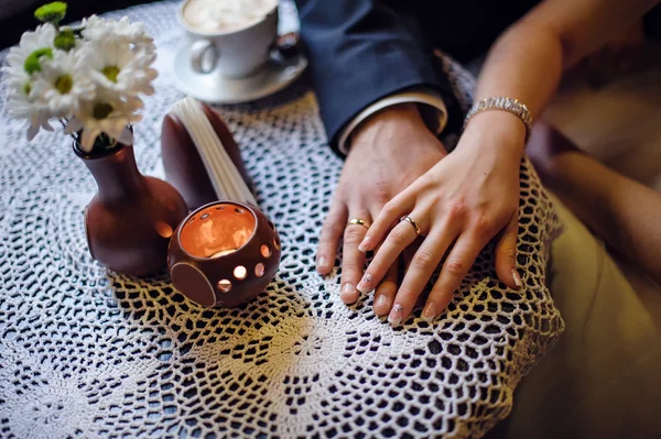 Руки нареченого і нареченого крупним планом на столі — стокове фото