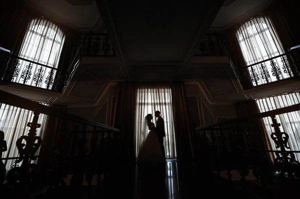 Silhueta de noiva e noivo no interior contra a janela — Fotografia de Stock