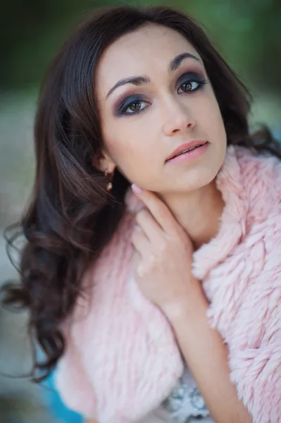 Beautiful woman in a pink cape walks in the park — Stock Photo, Image