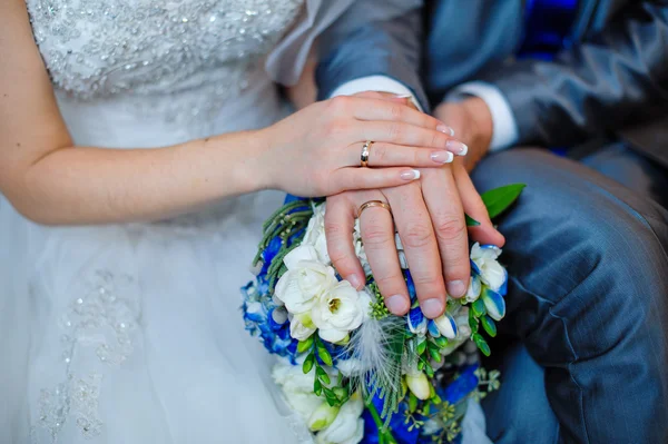 Hands of the bride and groom with the rings lying on the bridal — Stock Photo, Image