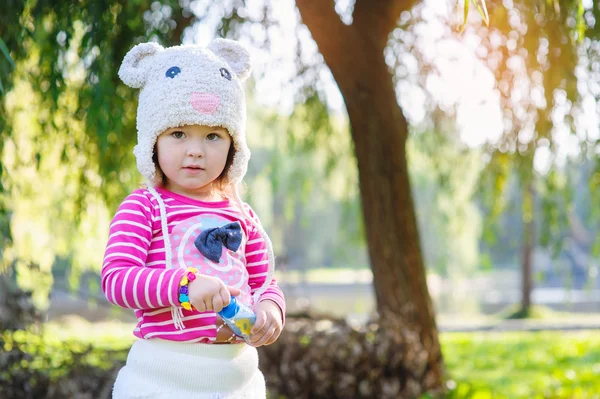 Little girl in the summer park holding a soap bubbles — Stock Photo, Image