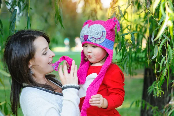 Vacker kvinna mamma med ett barn promenader i parken i sommar — Stockfoto