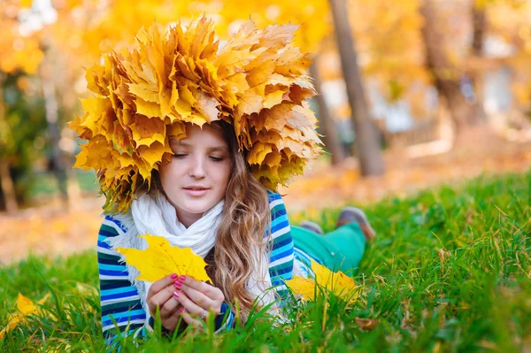 Beautiful girl with a wreath of leaves on the head lying on the — Stock Photo, Image