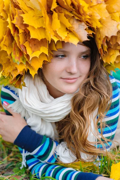 Beautiful girl with a wreath of leaves on the head lying on the — Stock Photo, Image