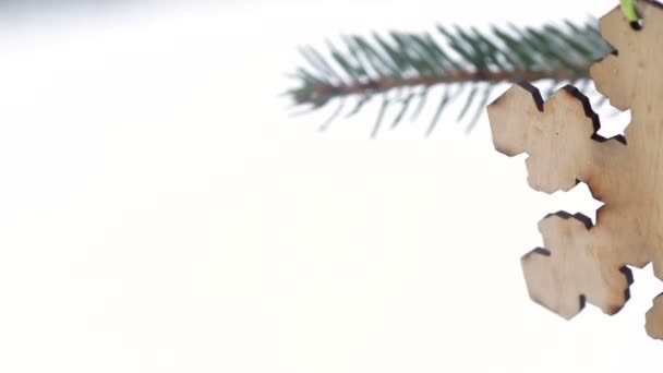 Hermoso juguete de madera en forma de copos de nieve colgando en el árbol de Navidad en invierno — Vídeos de Stock