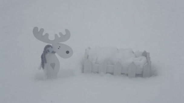 Cerca de madeira branca decorativa e alce na neve — Vídeo de Stock