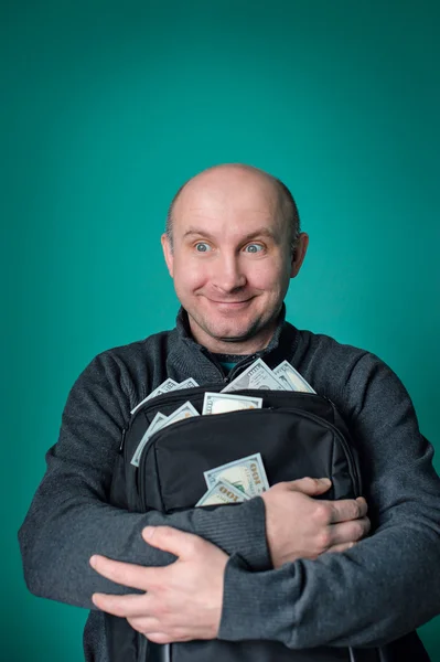 Ενθουσιασμένος επιχειρηματίας κρατώντας τσάντα με χρήματα και χαμογελώντας — Φωτογραφία Αρχείου