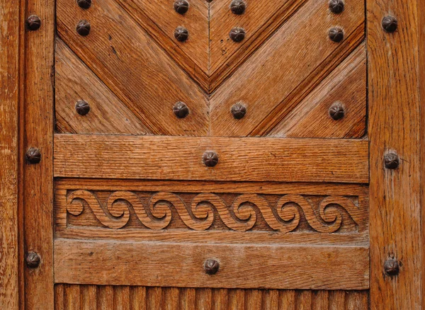 Коричневая деревянная дверь с металлическими заклепками — стоковое фото