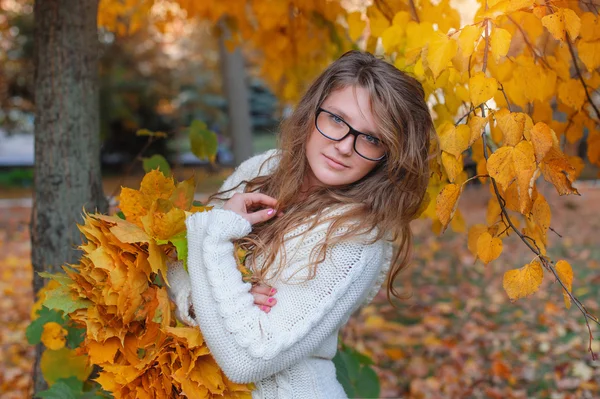 Beautiful woman with glasses walks in autumn park — Stock Photo, Image