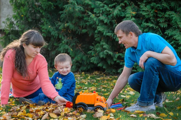 Jeune famille marchant dans le jardin d'automne — Photo