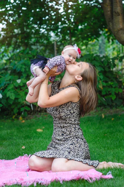 Felice madre e bambina che riposano nel giardino estivo — Foto Stock