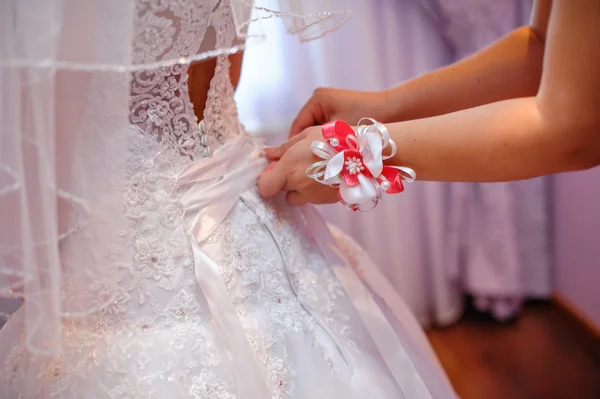 신부 들러리는 하얀 웨딩 드레스를 입는 신부를 돕는 — 스톡 사진