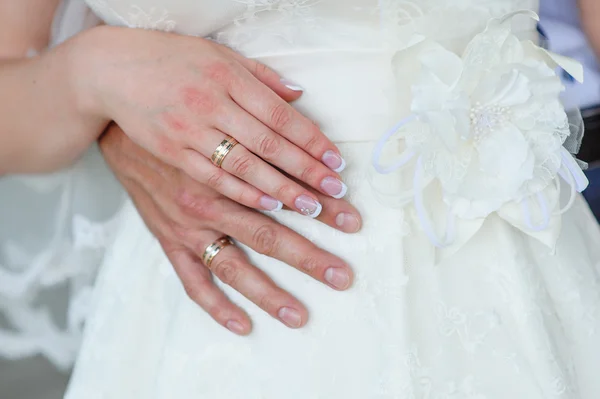 Les mains du marié et de la mariée avec des alliances — Photo