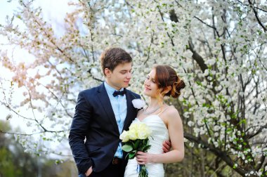 Gelin ve damat stand yakınındaki bir çiçekli ağaç bahar bahçe