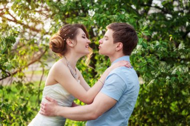 Mutlu gelin ve damat bahar bahçede öpüşme