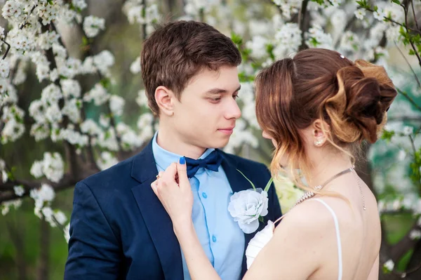Bruden korrigerar för att brudgummen fjärilen på bakgrund av en flo — Stockfoto