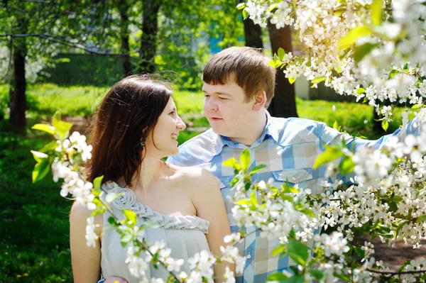 Schöner Mann und Frau beim Spazierengehen im blühenden Frühlingspark — Stockfoto