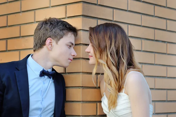 Bride and groom stand on the corner of a brick building look at each one — Stock Photo, Image