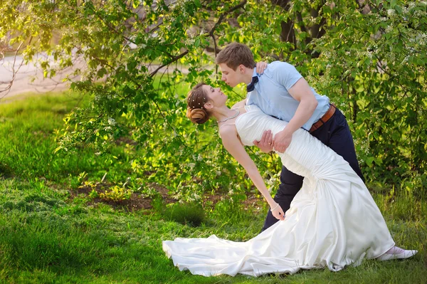 緑豊かな公園で春に野外を歩いている日を結婚式で新郎新婦 — ストック写真