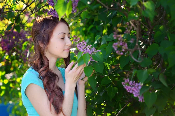 Retrato de mulher jovem perto do lilás florescente — Fotografia de Stock