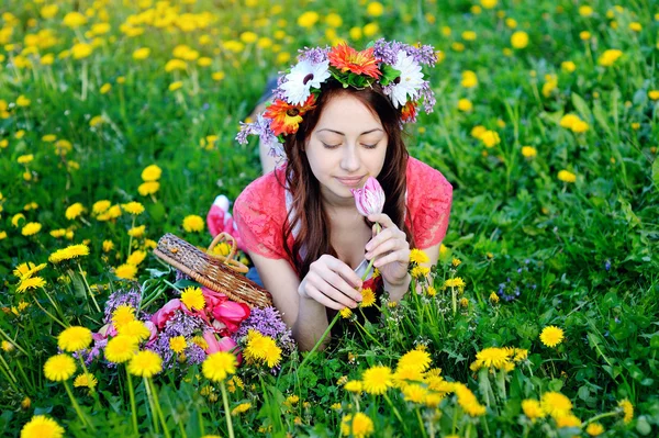 美丽的女人，穿着红色的躺在草地上，黄色的花 — 图库照片
