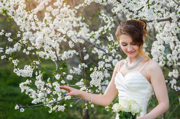 Beautiful bride in a blossoming spring garden — Stock Photo, Image