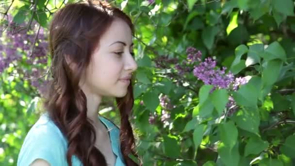 Mujeres jóvenes caminando fuera en un árbol de lilas parque — Vídeos de Stock