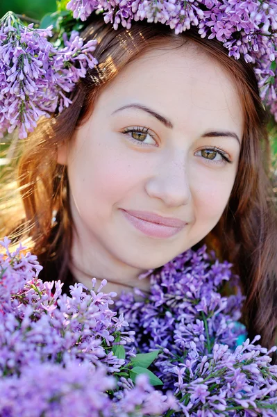 Hermosa mujer sosteniendo un ramo de lilas en el parque de primavera —  Fotos de Stock