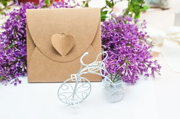 Belle printemps lilas petit vélo blanc et boîte cadeau sur un fond — Photo