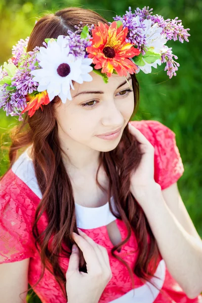 Mulher bonita com flores de grinalda no jardim da primavera — Fotografia de Stock