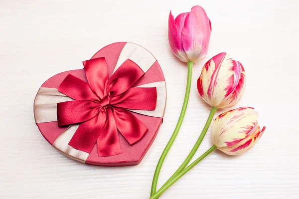 Tulipanes y caja de regalo sobre fondo blanco — Foto de Stock