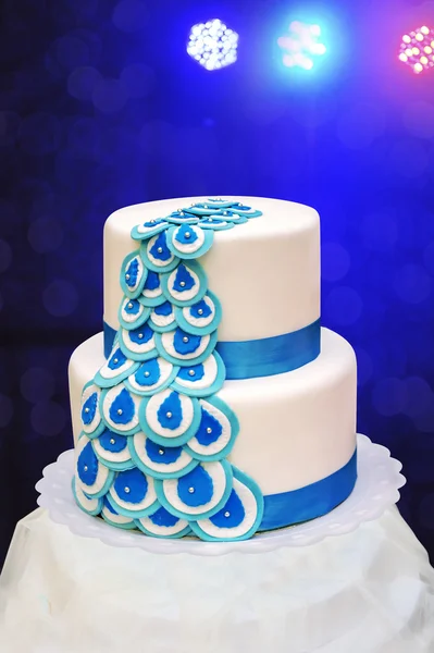 Hermosa torta blanca de tres niveles sobre un fondo azul —  Fotos de Stock