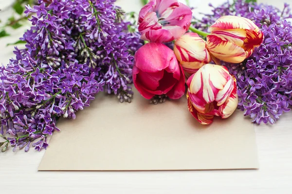 Tulips and lilac branch greeting card on a light background — Stock Photo, Image