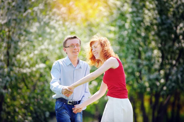 Bruden och brudgummen gå i blommande våren trädgård — Stockfoto
