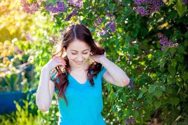 Chica feliz caminando en el jardín de primavera Lila —  Fotos de Stock