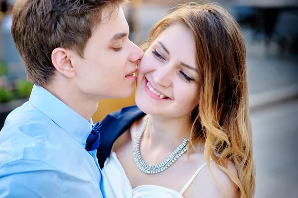 Groom kisses the bride on walk in wedding day — Stock Photo, Image