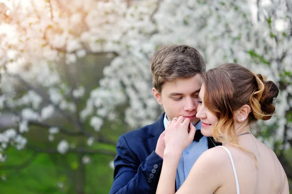 Sposa e sposo che camminano nel giardino primaverile fiorito — Foto Stock