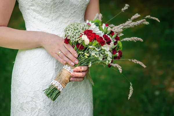 Bruid, mooie bruiloft boeket over natuur houden — Stockfoto