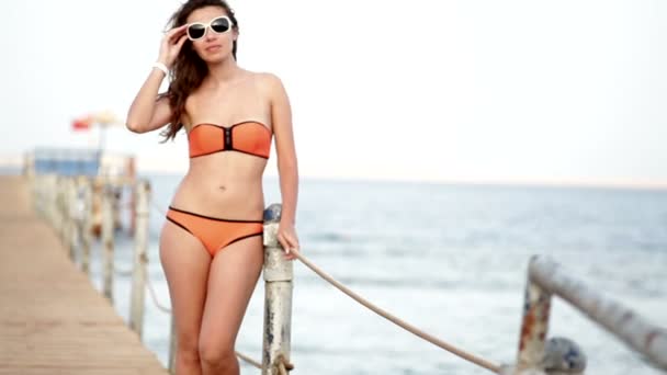 Красива жінка в сонцезахисних окулярах позує на понтон — стокове відео