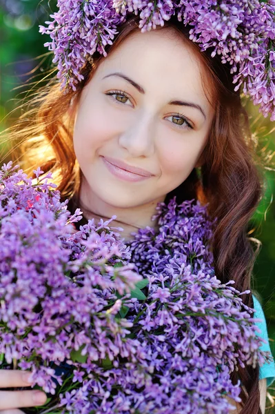 ライラックの花束とライラックの花輪で美しい少女 — ストック写真