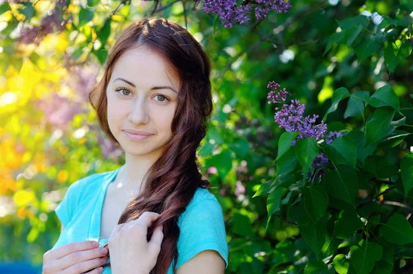 Schönes lächelndes Mädchen in blauem T-Shirt auf fliederfarbenem Hintergrund — Stockfoto